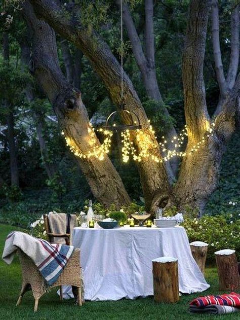 Outdoor table setting under string light chandelier