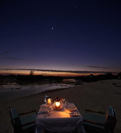 Table set on a beach with lantern centerpiece