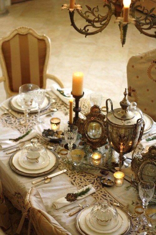 Table set with vintage lace tablecloth white china and silver holloware